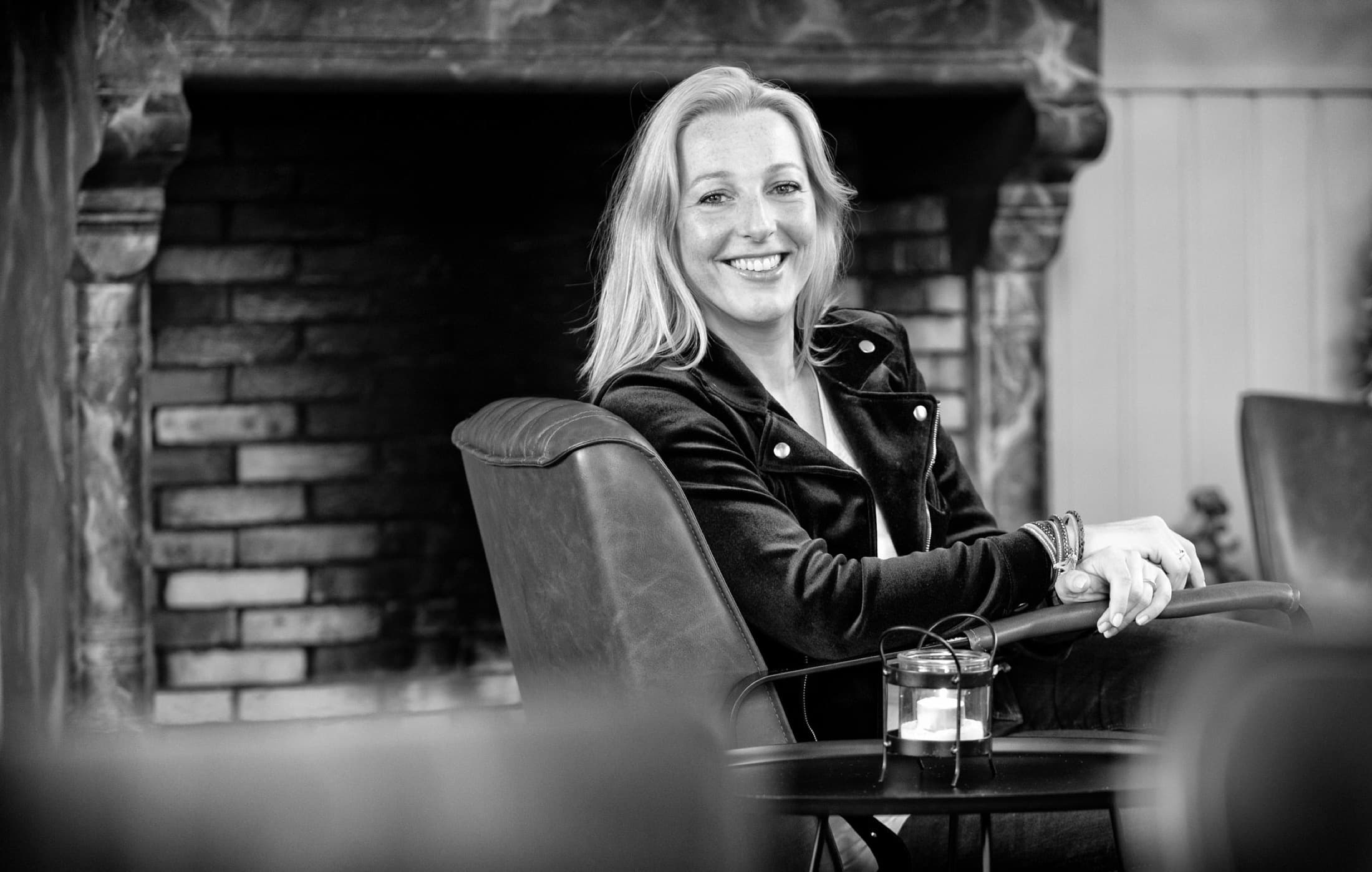 Laura Evers ontspannen in een fauteuil, zwart-wit